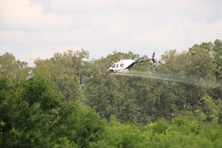 applying herbicide for vegetation control by helicopter